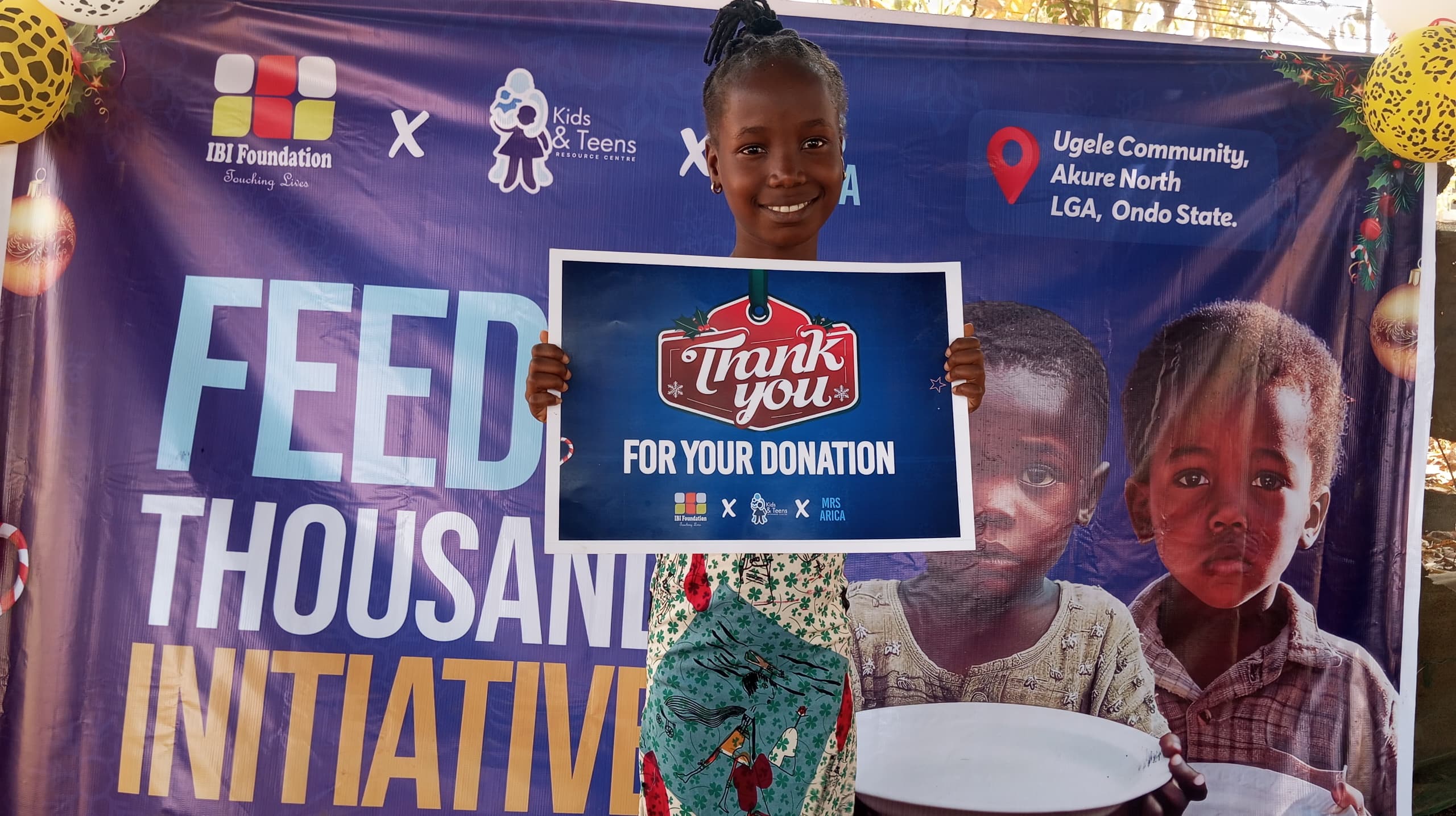 A girl holding a "Thank you for your Donation" Placard during the FATI Christmas event in Ugele Community, Akure North LGA.